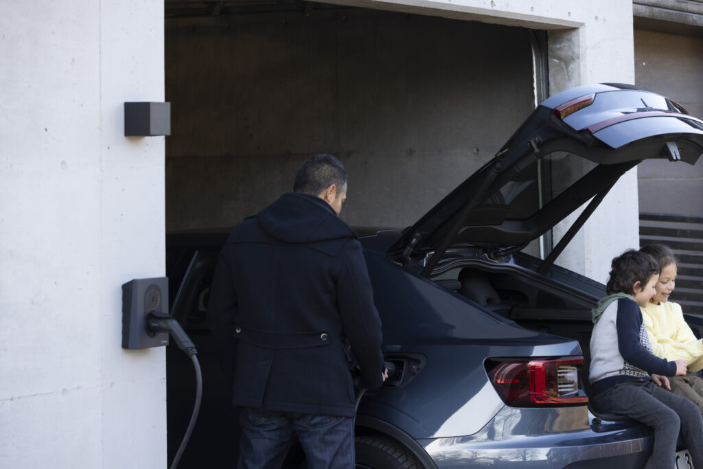 Mann lädt sein Auto an einer Wallbox